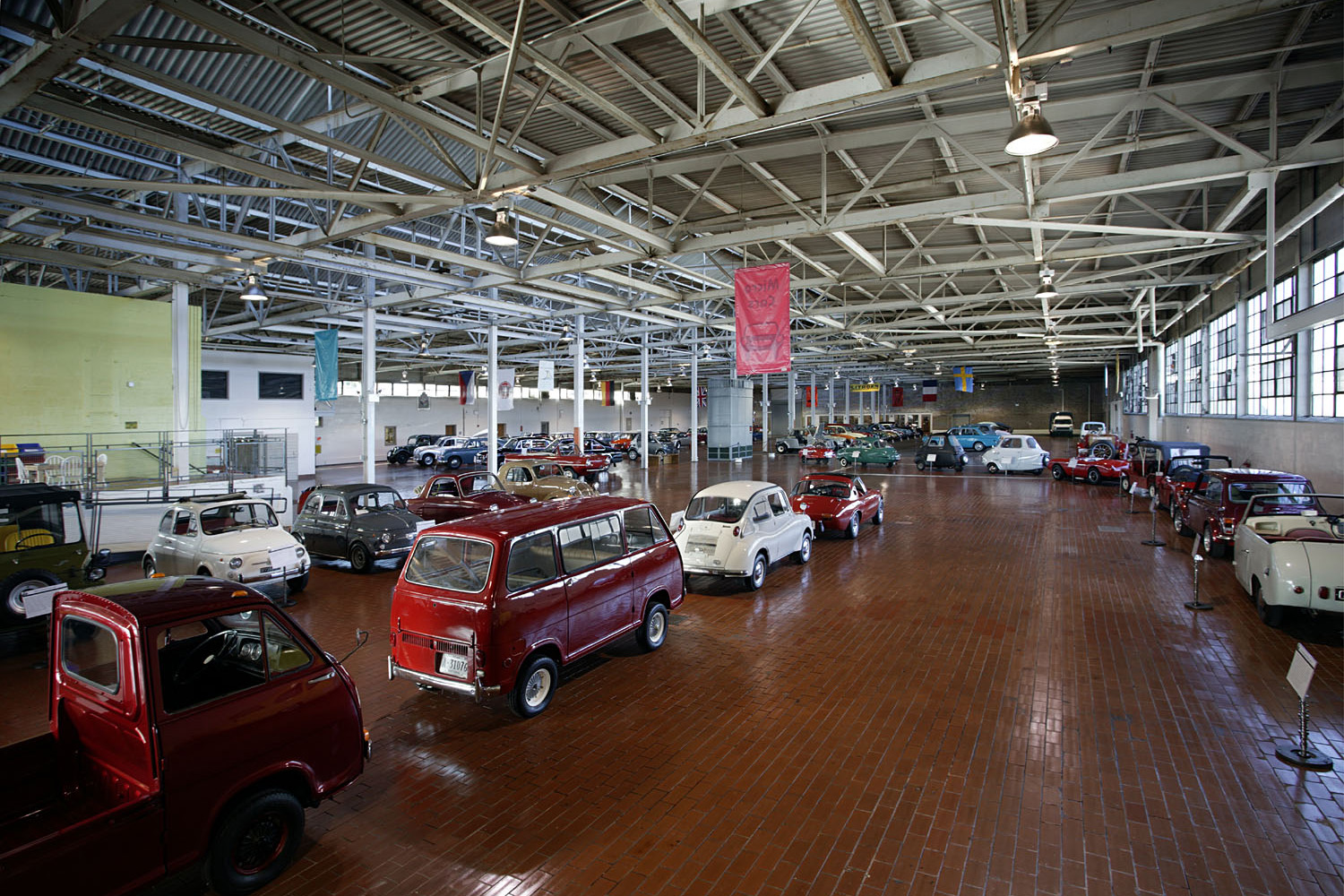 The Lane Motor Museum, vintage cars beneath the trusses of a preserved industrial building.